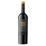 A bottle of Campos de Solana Tri Varietal Gran Reserva Tinto with a dark glass body and a black label featuring bold gold “TRI” lettering, set against a black background.